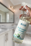 A person spraying bathroom cleaner in their washroom, for a clean and eco-friendly home.